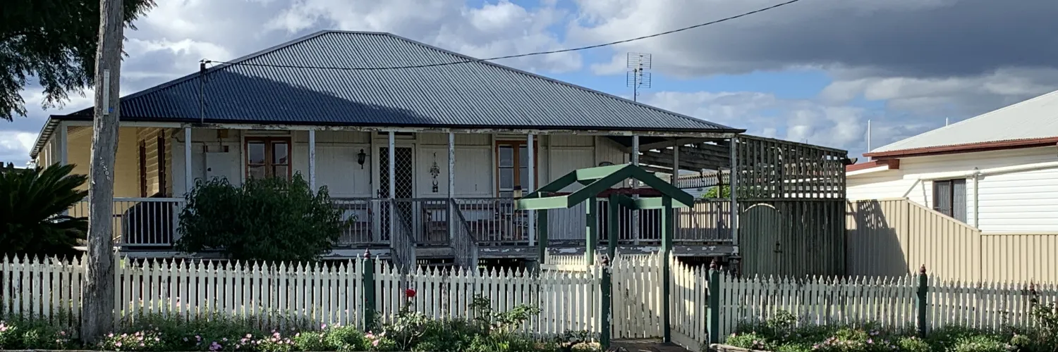 A raised timber house behind a white picket fence in Ascot, in the Toowoomba region of Queensland