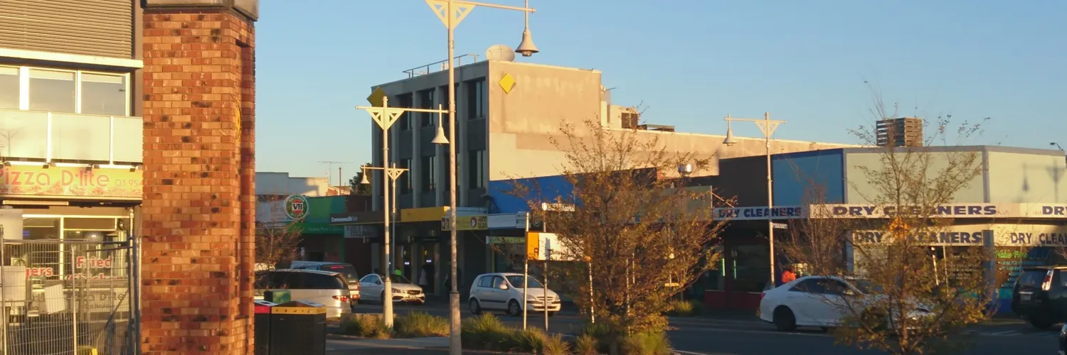 Shops, street lights and a brick pillar in the Noble Park town centre, Melbourne