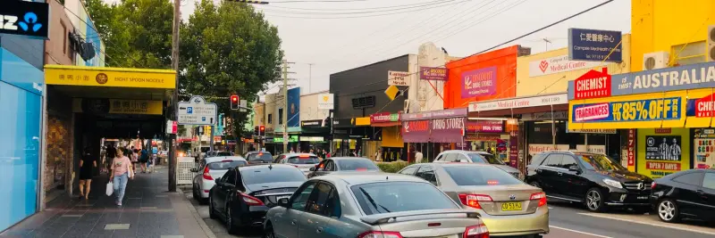 Shops, signs and parked cars along Beamish Street in Campsie, Sydney