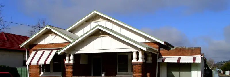 A brick Californian bungalow with striped awnings on a street in Wagga Wagga, New South Wales