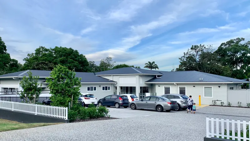 Single-storey childcare centre with a car park and white picket fence in Corinda, Brisbane