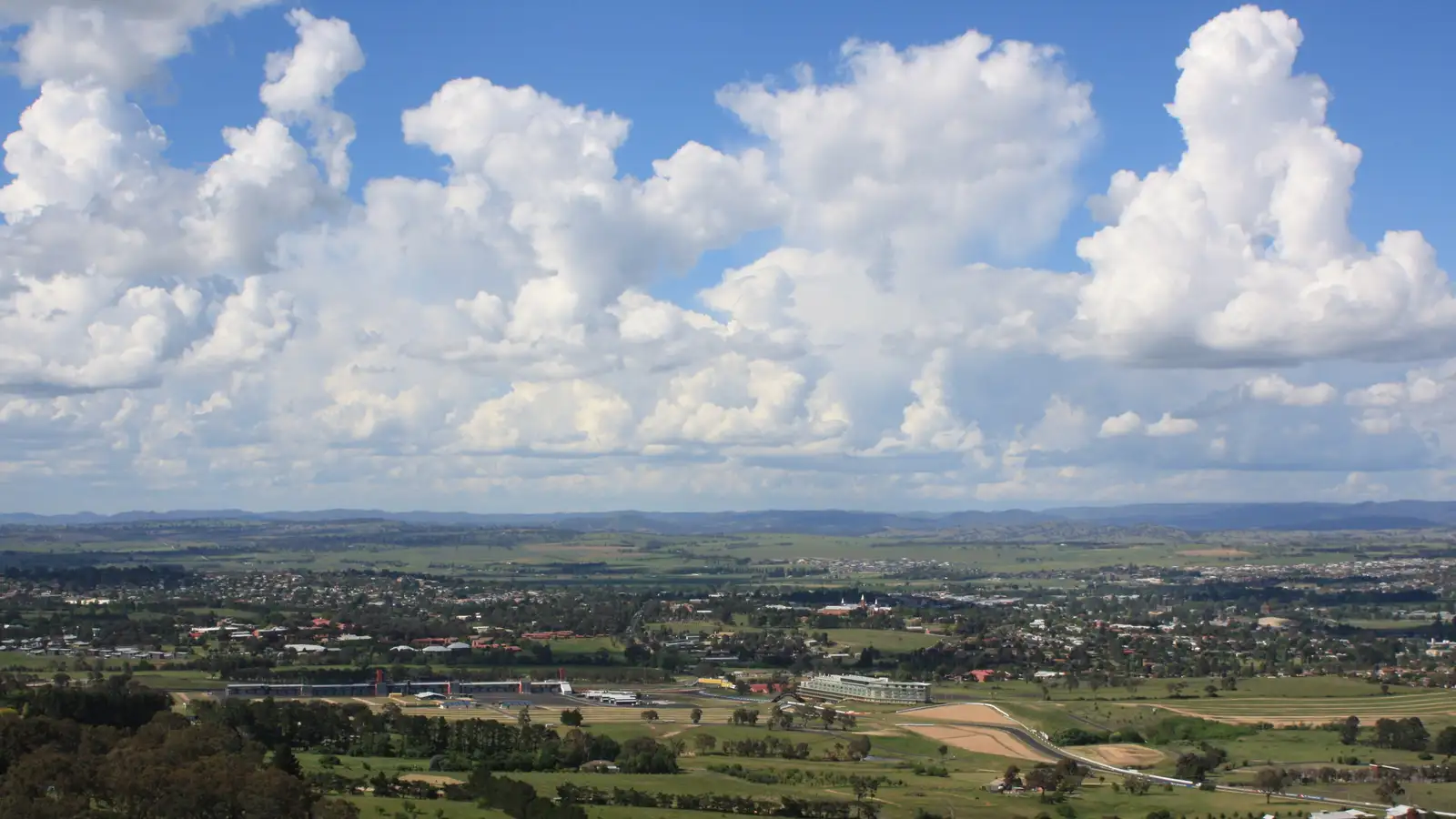 Panoramic view over Bathurst and the surrounding farmland under a bright sky with clouds