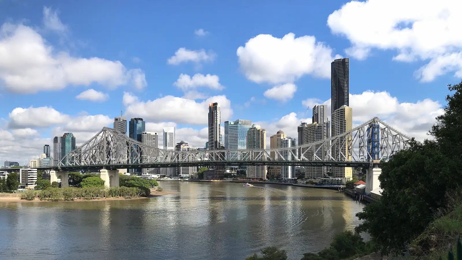 Brisbane CBD towers and the Story Bridge over the Brisbane River under a blue sky