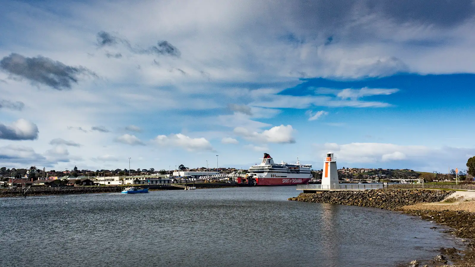 Mersey River at Devonport with a lighthouse, and a ferry at berth under a blue sky