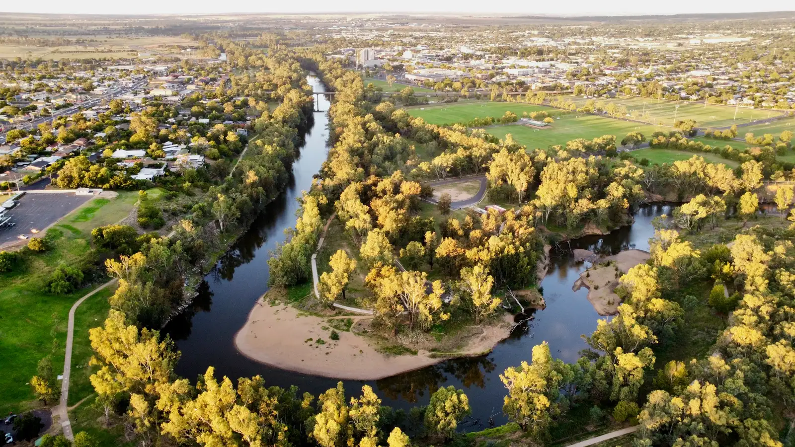 Aerial view of the Macquarie River (Wambuul) winding through green parkland in Dubbo