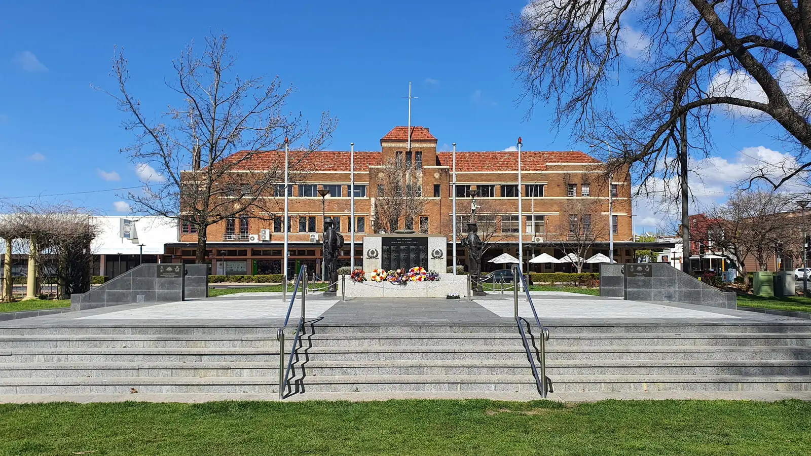 Orange war memorial and Robertson Park with the heritage civic building behind, under a blue sky