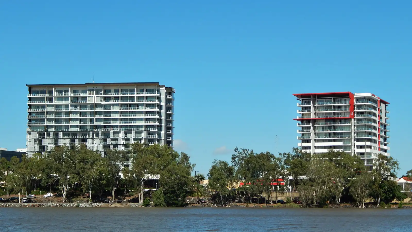 Rockhampton riverfront apartment buildings across the Fitzroy River under a blue sky