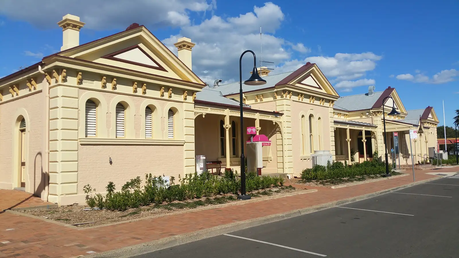Tamworth's heritage railway station buildings with lamp posts along a paved street under a blue sky
