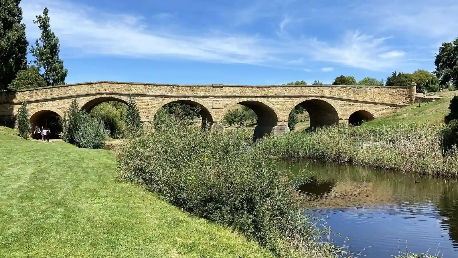 Richmond Bridge, a sandstone arch bridge, over the Coal River in Tasmania under a blue summer sky